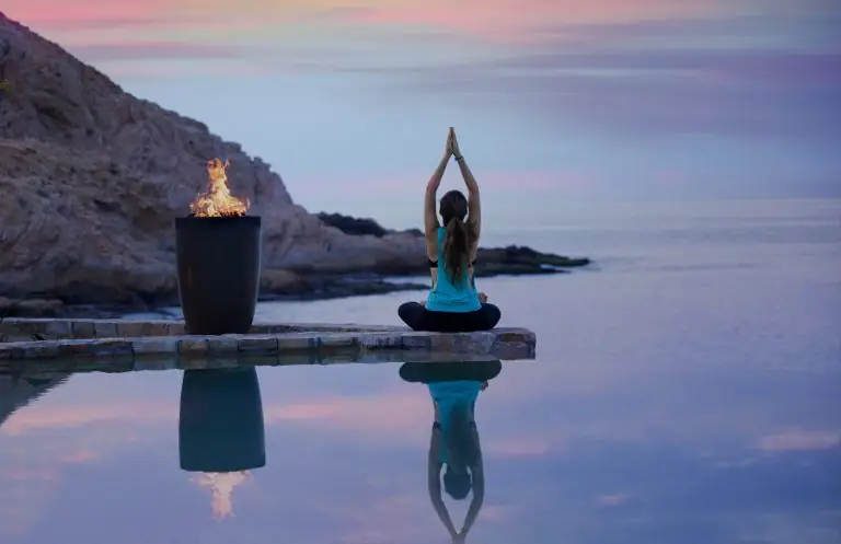Woman doing yoga at sunset