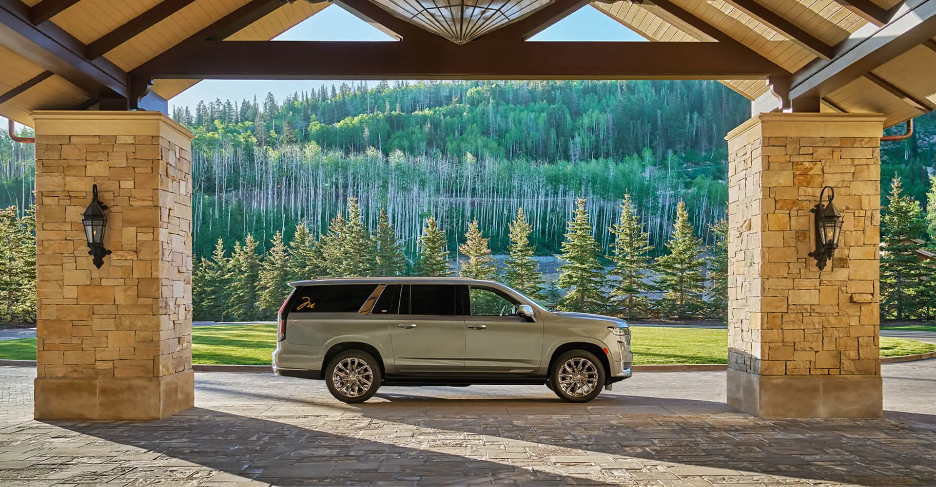 Cadillac in Montage Deer Valley drive, with lots of bright green trees in background