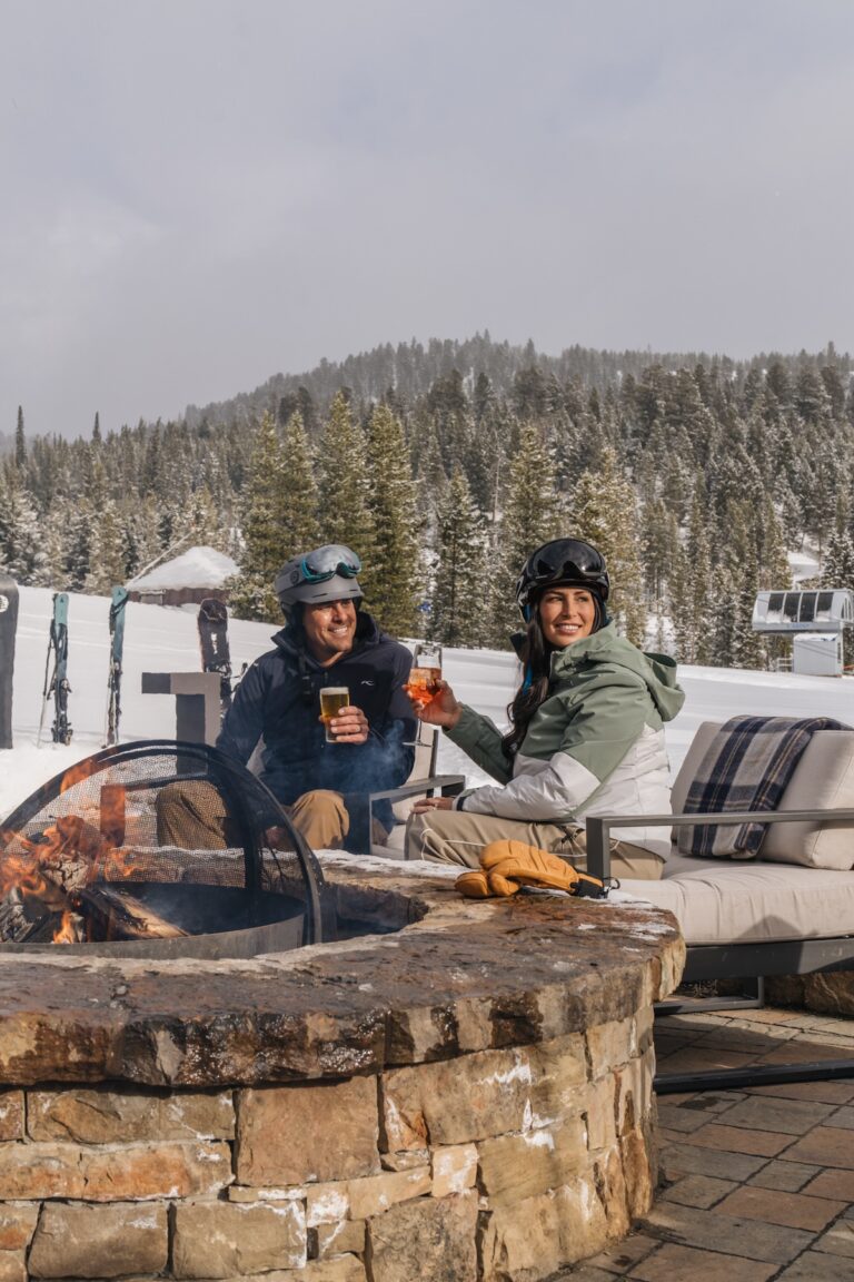 A couple having cocktails by the fire at Montage Big Sky