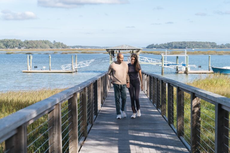 A couple walking on a dock at Montage Palmetto Bluff