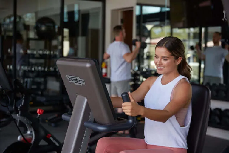 Woman exercising on Technogym bike in gym