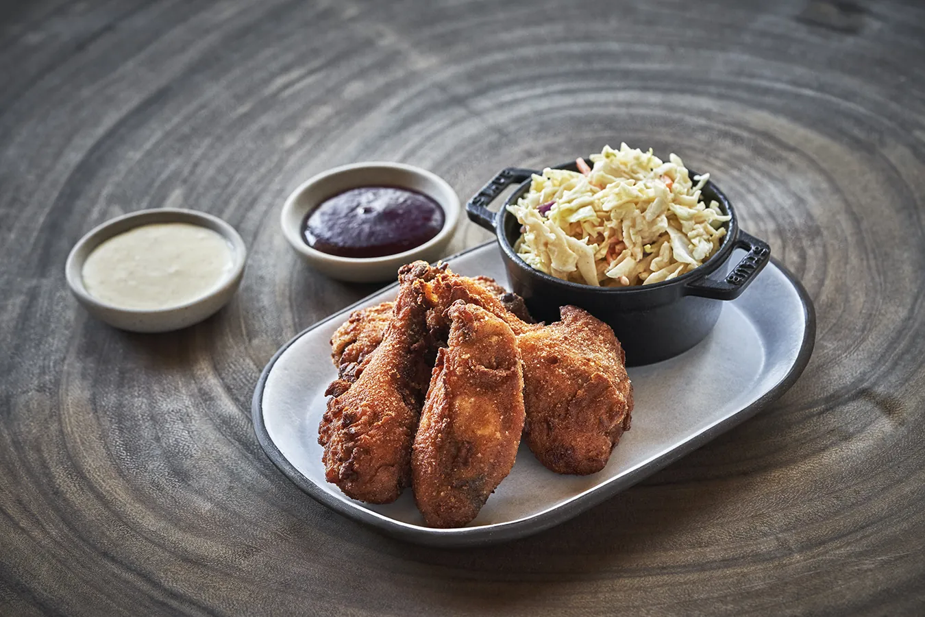 Fried chicken with a side of cole slaw and sauces