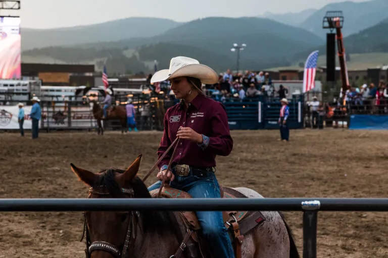 A woman riding a horse at the rodeo