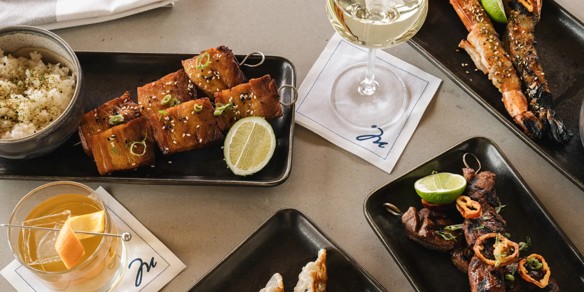 Yakitori meat skewers with various cocktails on a table