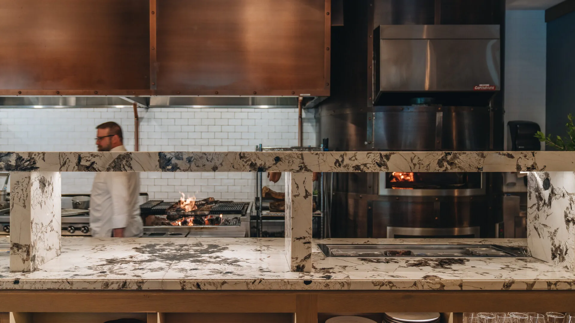 A chef walking past the kitchen in Cortina