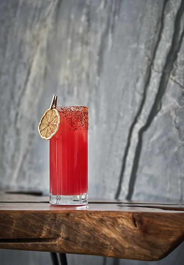 Pink cocktail with dried fruit garnish at Alpenglow