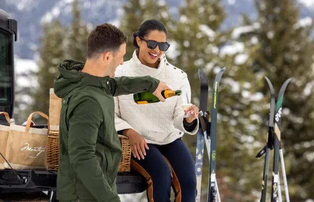 Couple enjoying champagne outdoors in the snow