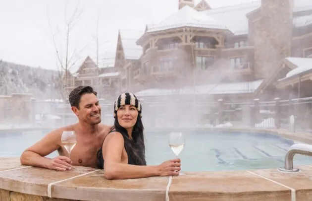 Couple relaxing with wine in a steaming outdoor pool