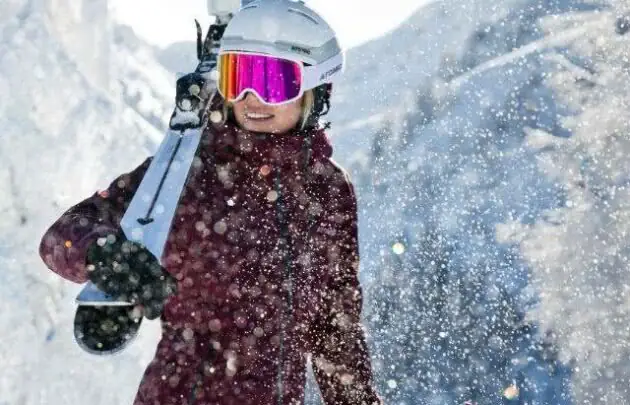 Skier carrying skies on shoulder