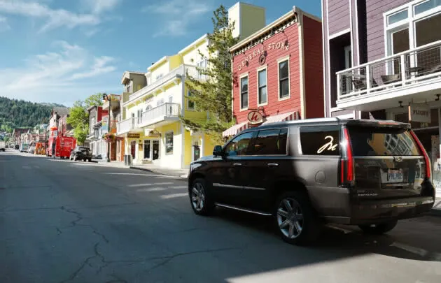 A Cadillac driving up main street in Park City.