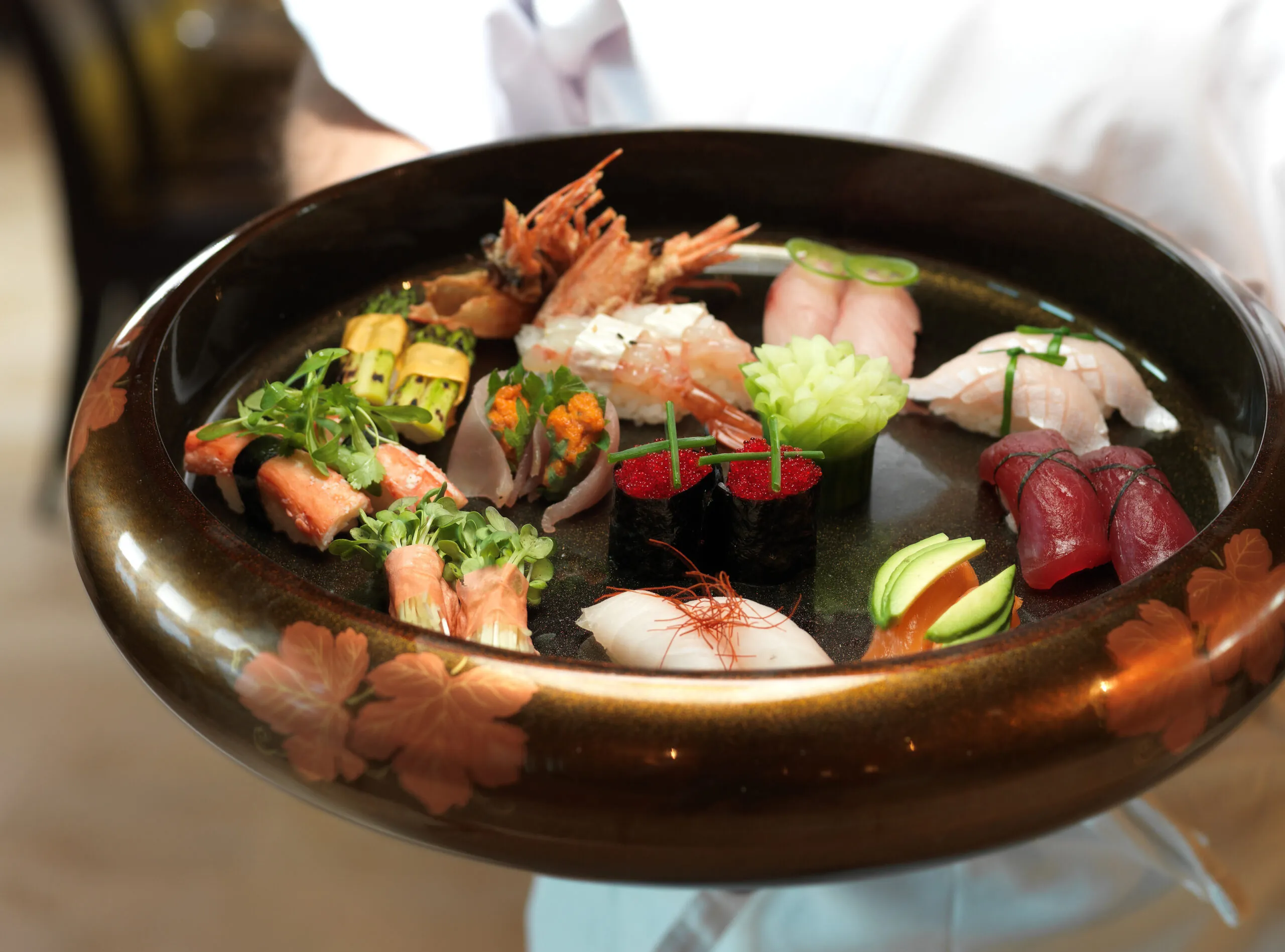 A bowl of sushi, featuring an array of colorful and mouthwatering sushi rolls