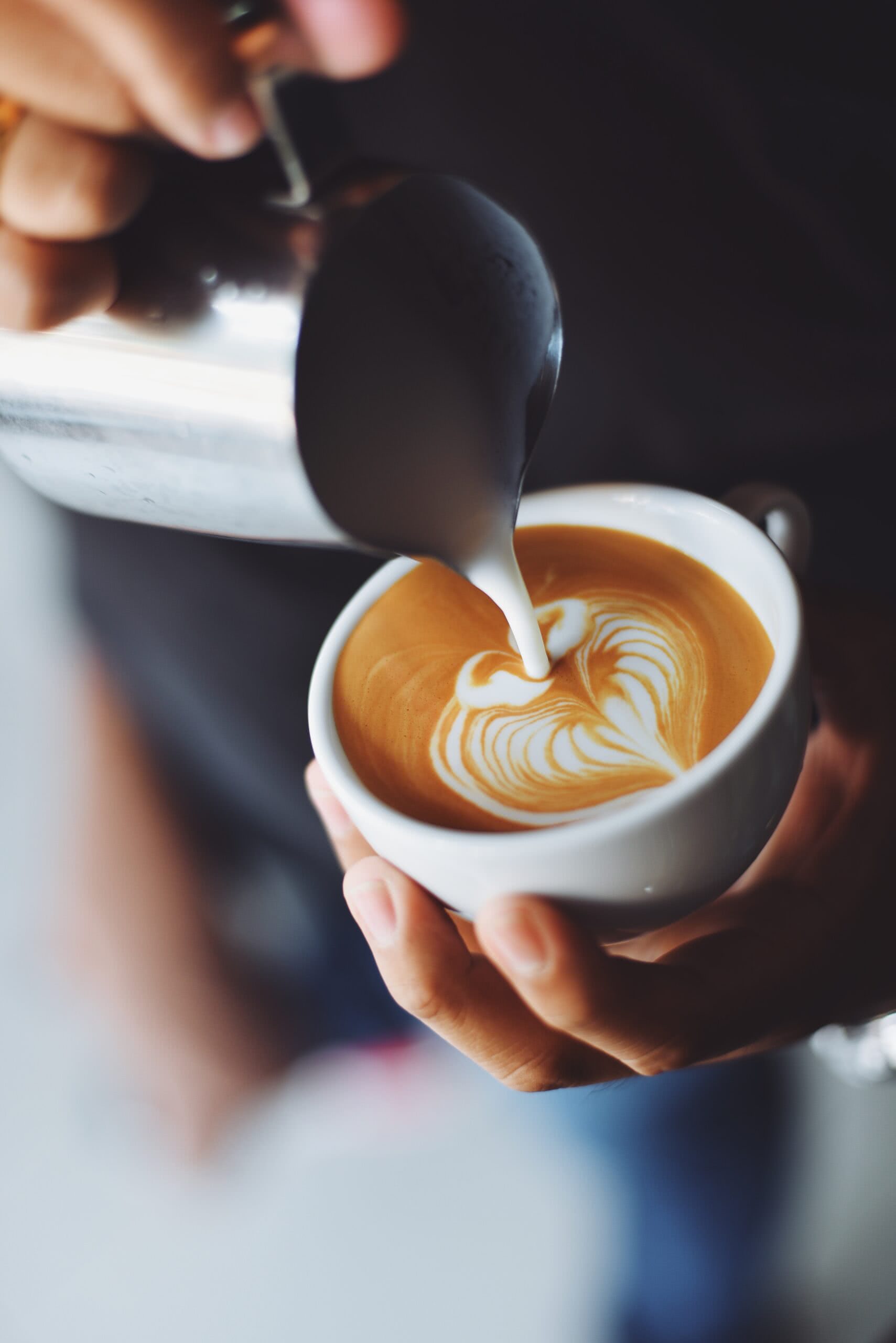 A person pouring coffee into a cup.