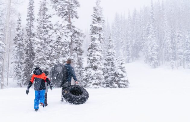 A family tubing in the snow at Montage Deer Valley.