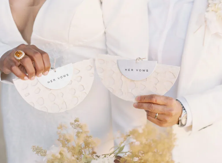 two people holding vow fans