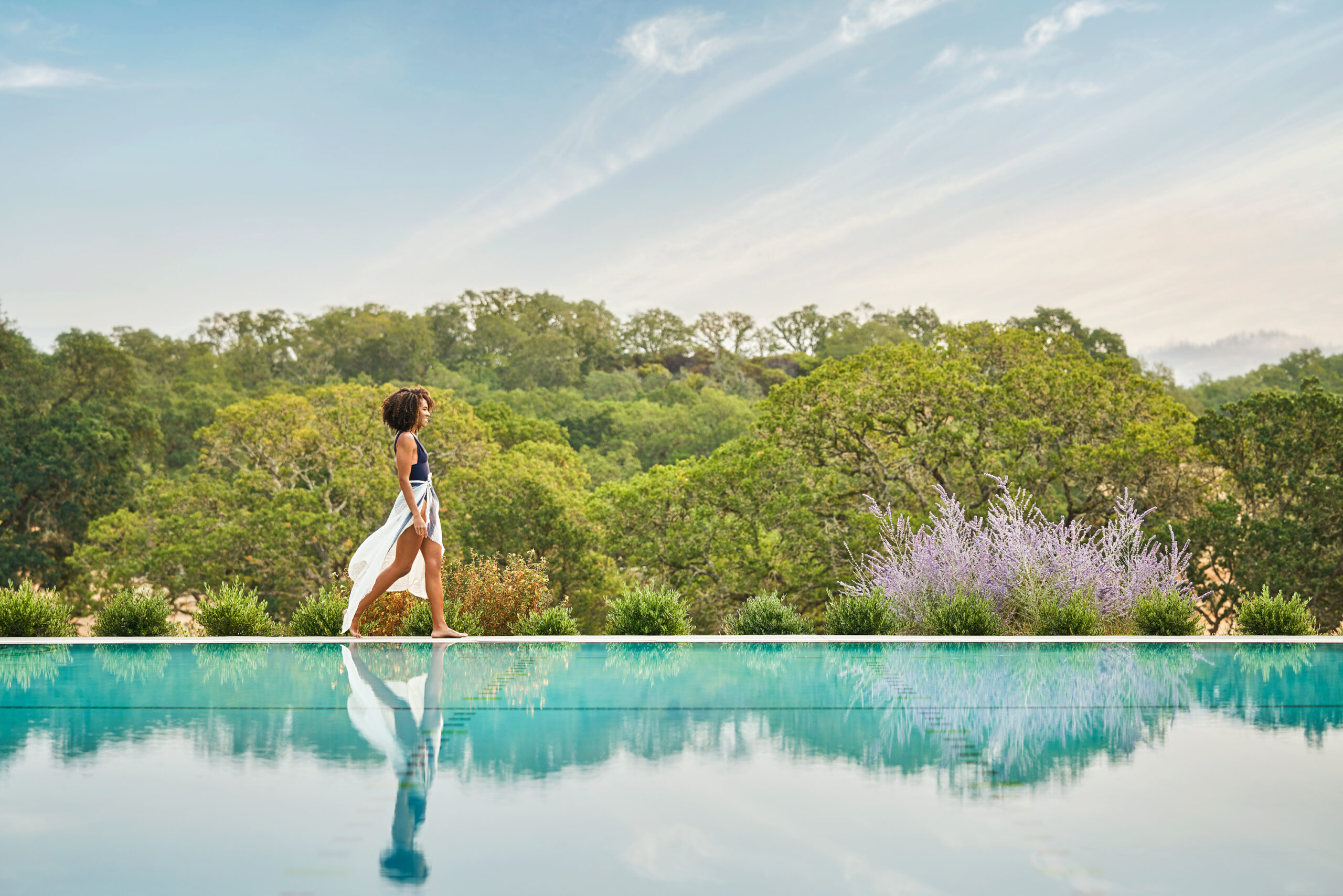 Woman walking alongside the pool at luxury napa valley resort, Montage Healdsburg