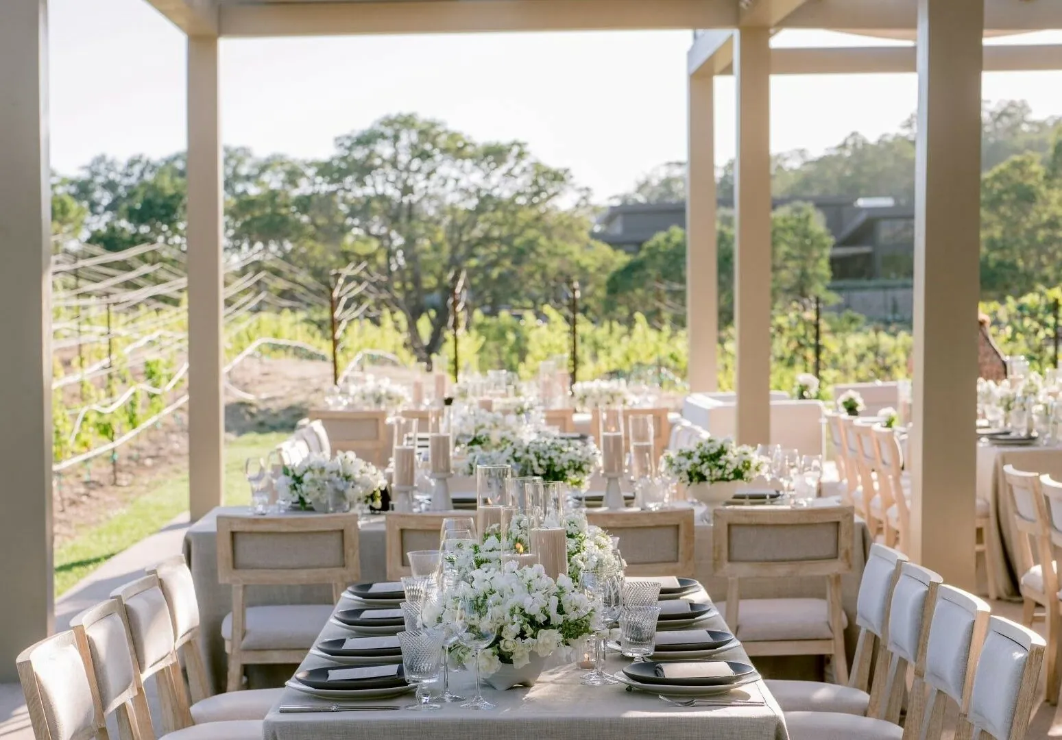 tables under pergola with vineyard views