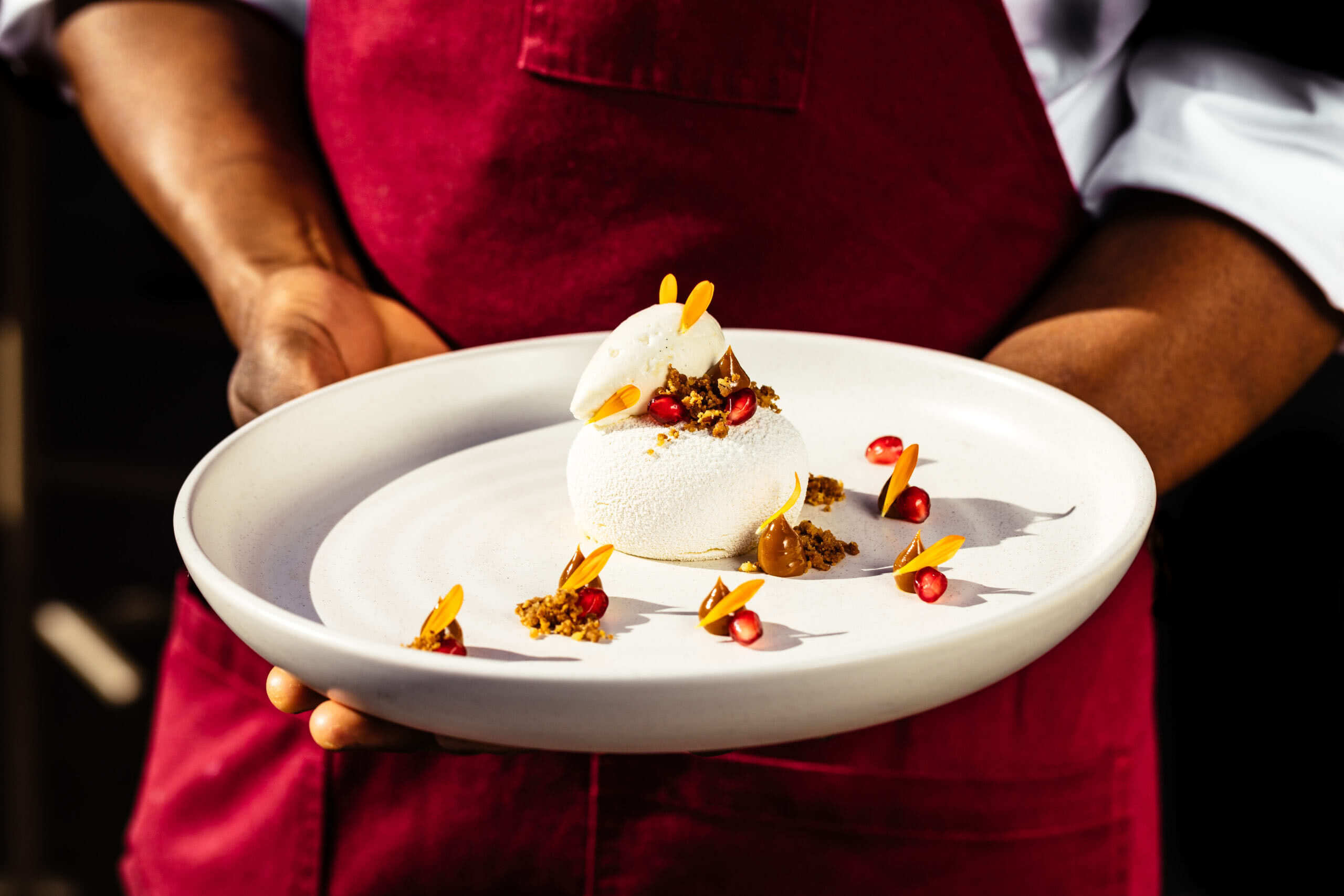 restaurant server holding white plate of food