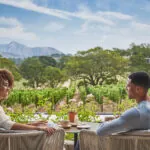 Couple dining outside overlooking napa valley vineyards at luxury resort, Montage Healdsburg