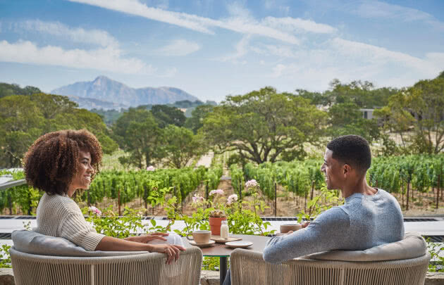 Couple dining outside overlooking napa valley vineyards at luxury resort, Montage Healdsburg