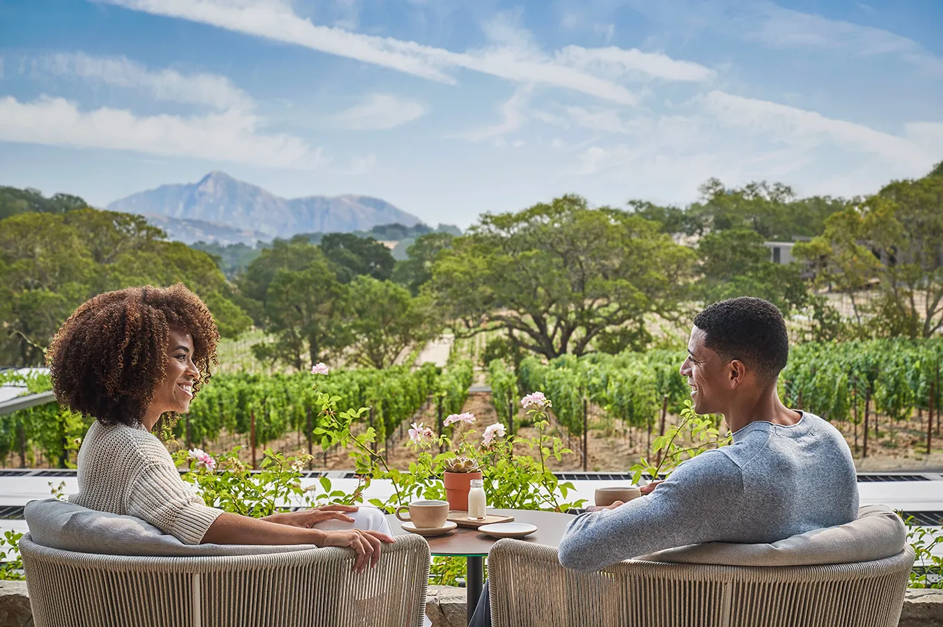 Couple dining outside overlooking napa valley vineyards at luxury resort, Montage Healdsburg