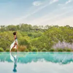 Woman walking alongside the pool at luxury napa valley resort, Montage Healdsburg