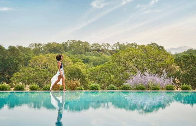Woman walking alongside the pool at luxury napa valley resort, Montage Healdsburg