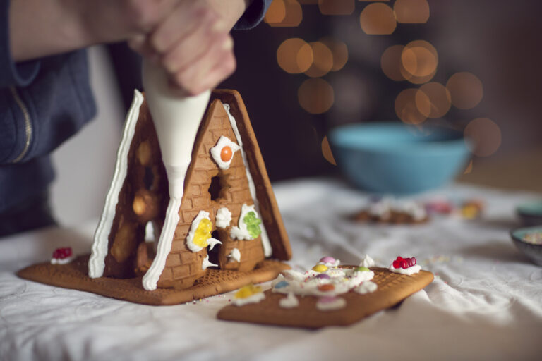 teenager decorating gingerbread house