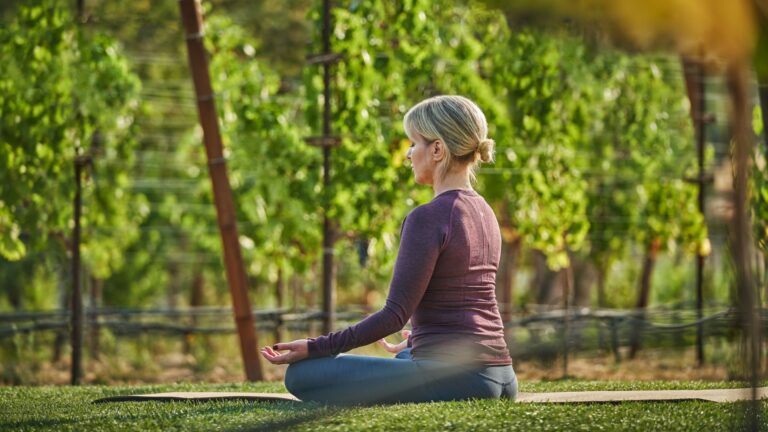 Woman meditating in a vineyard.