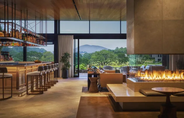 Lobby of Montage Healdsburg with fireplace, bar and views of vineyards and Mount St. Helena.