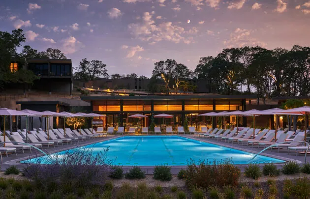 View of poo; and fitness center at dusk.