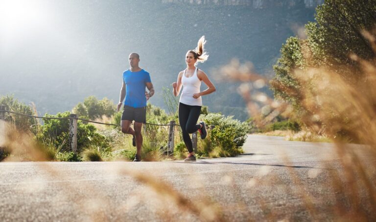 Shot of a sporty couple out running on a mountain road