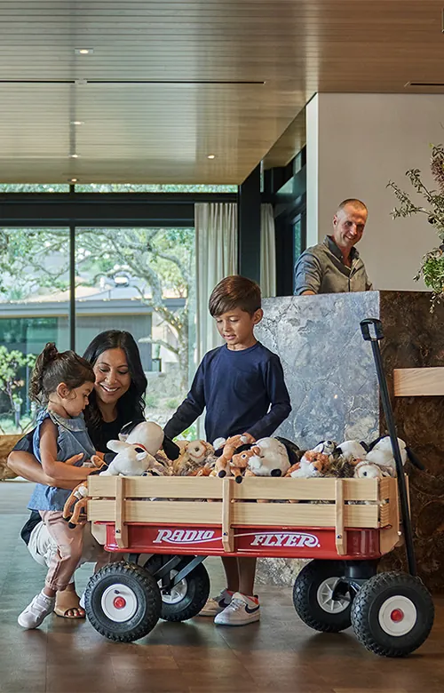Children playing with a wagon full of toys in the lobby at Montage Healdsburg