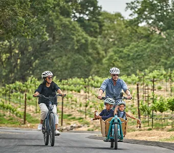 Two parents riding a bike with their child at Montage Healdsburg