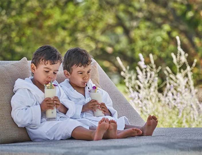 Two children drinking juice by the pool at Montage Healdsburg