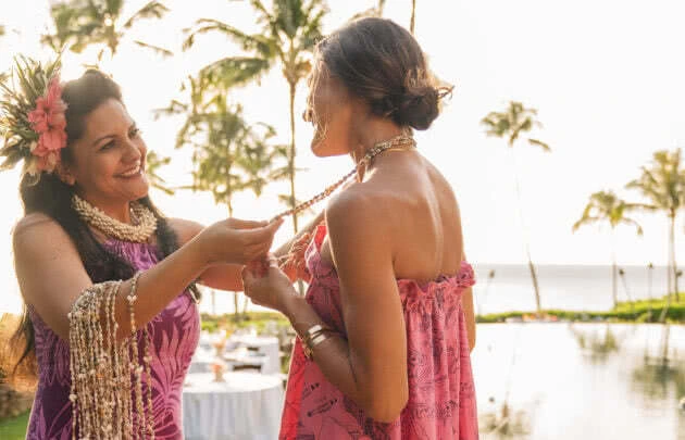 Woman receiving beads at Sunset Luau at Montage Kapalua Bay