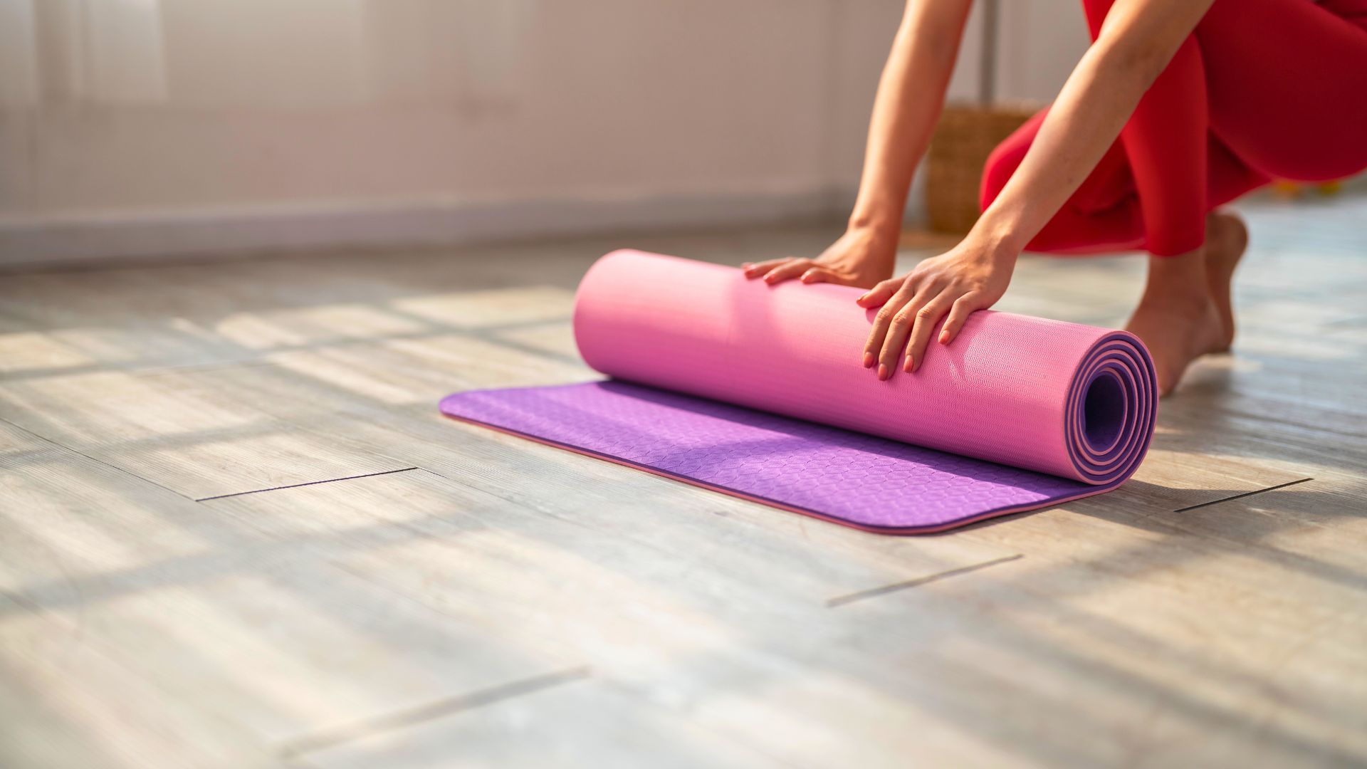 A woman rolling up a yoga mat at Spa Montage Kapalua Bay