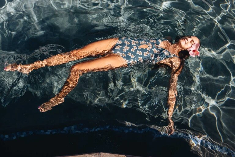A woman swimming at The Beach Club at Montage Kapalua Bay