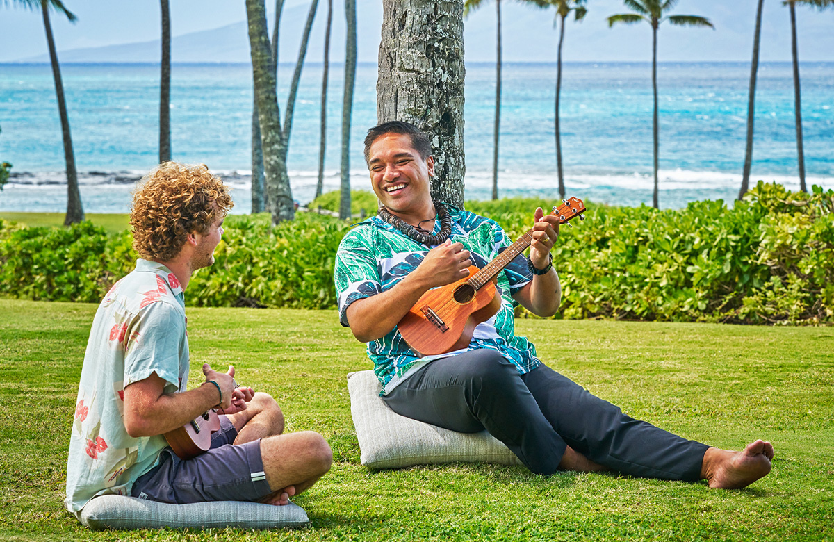 A boy learning how to play the ukulele at Montage Kapalua Bay