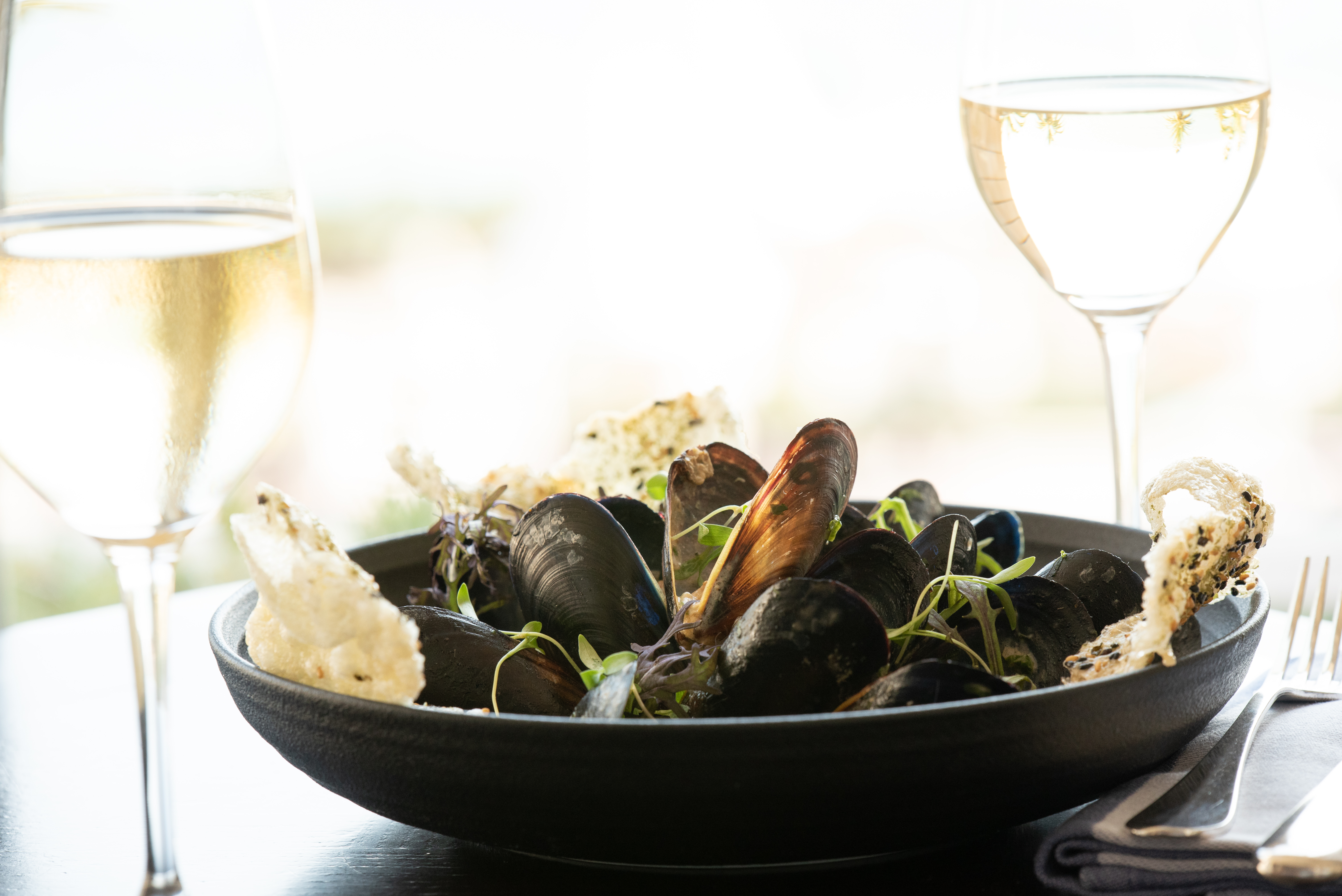 Mussels in black bowl with wine