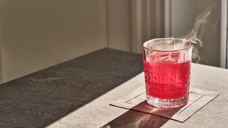 A pink hued cocktail in the sunlight at Studio