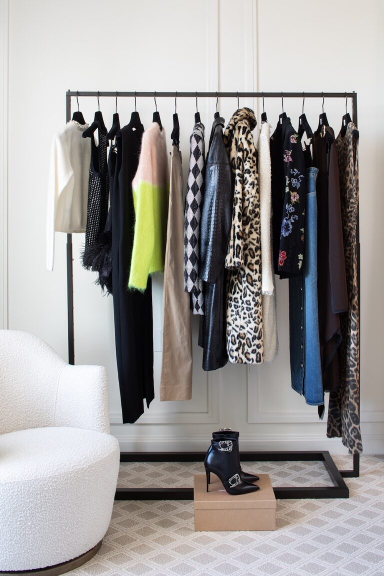 Clothing rack with designer outfits and boots in a boutique