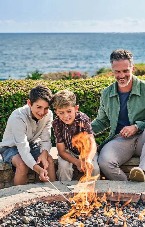 A family roasting marshmallows over a fire at Montage Laguna Beach