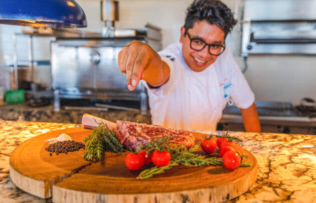 The chef at Marea seasoning a steak at Montage Los Cabos