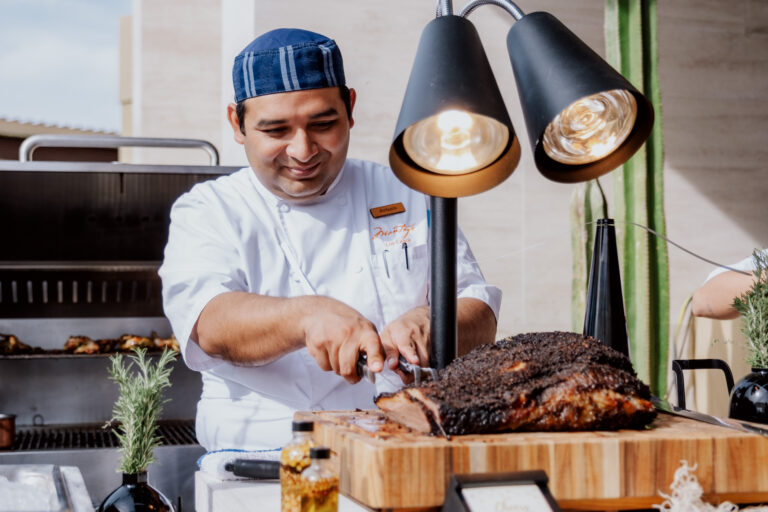 Chef cutting brisket by the grille at Montage Los Cabos