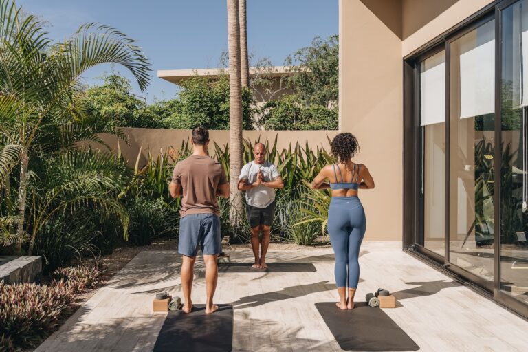A man and a woman doing yoga with an instructor.