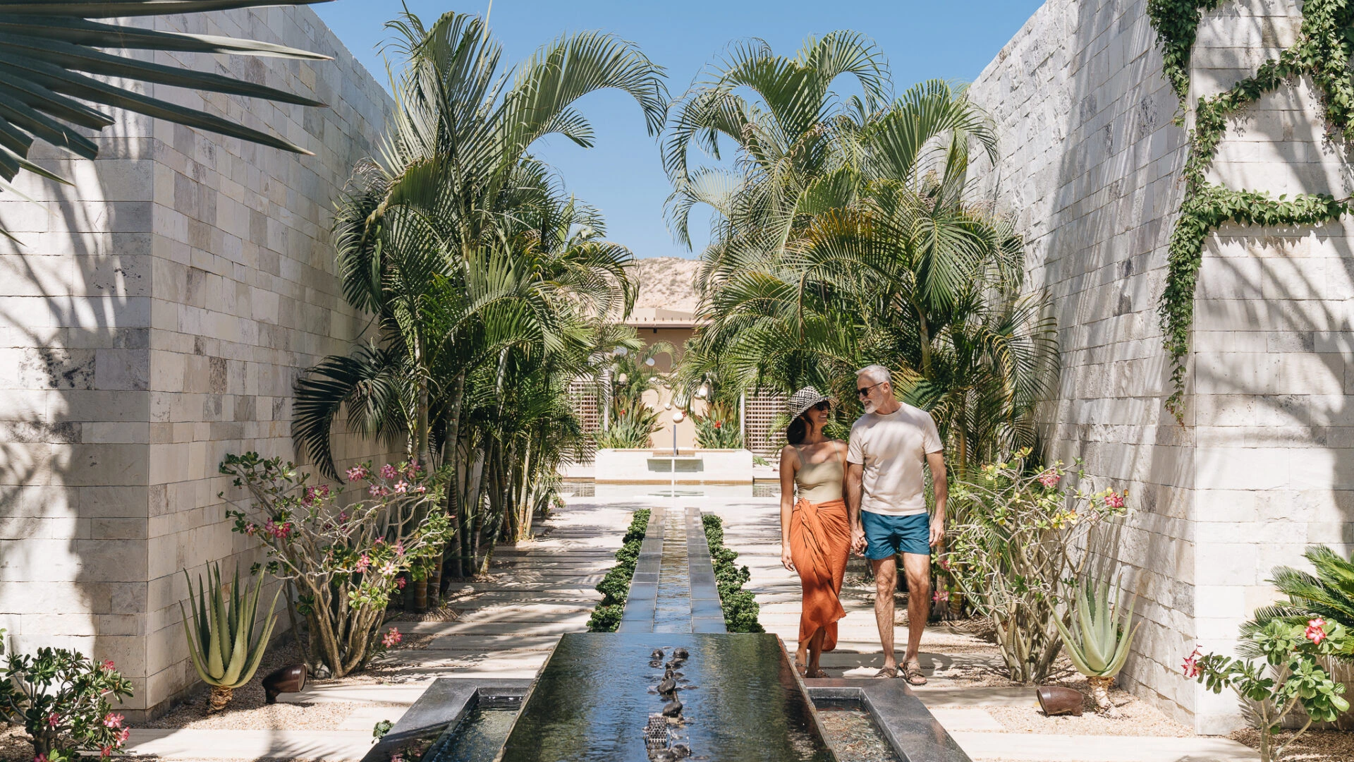Couple walking along water feature at Montage Los Cabos