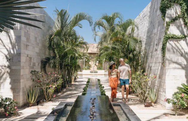 Couple walking along water feature at Montage Los Cabos