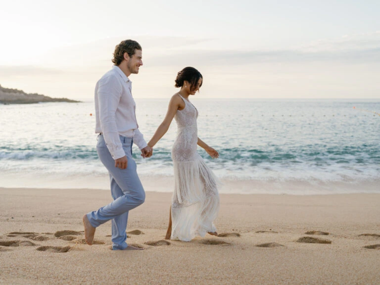 Engaged couple walking on beach at Montage Los Cabos