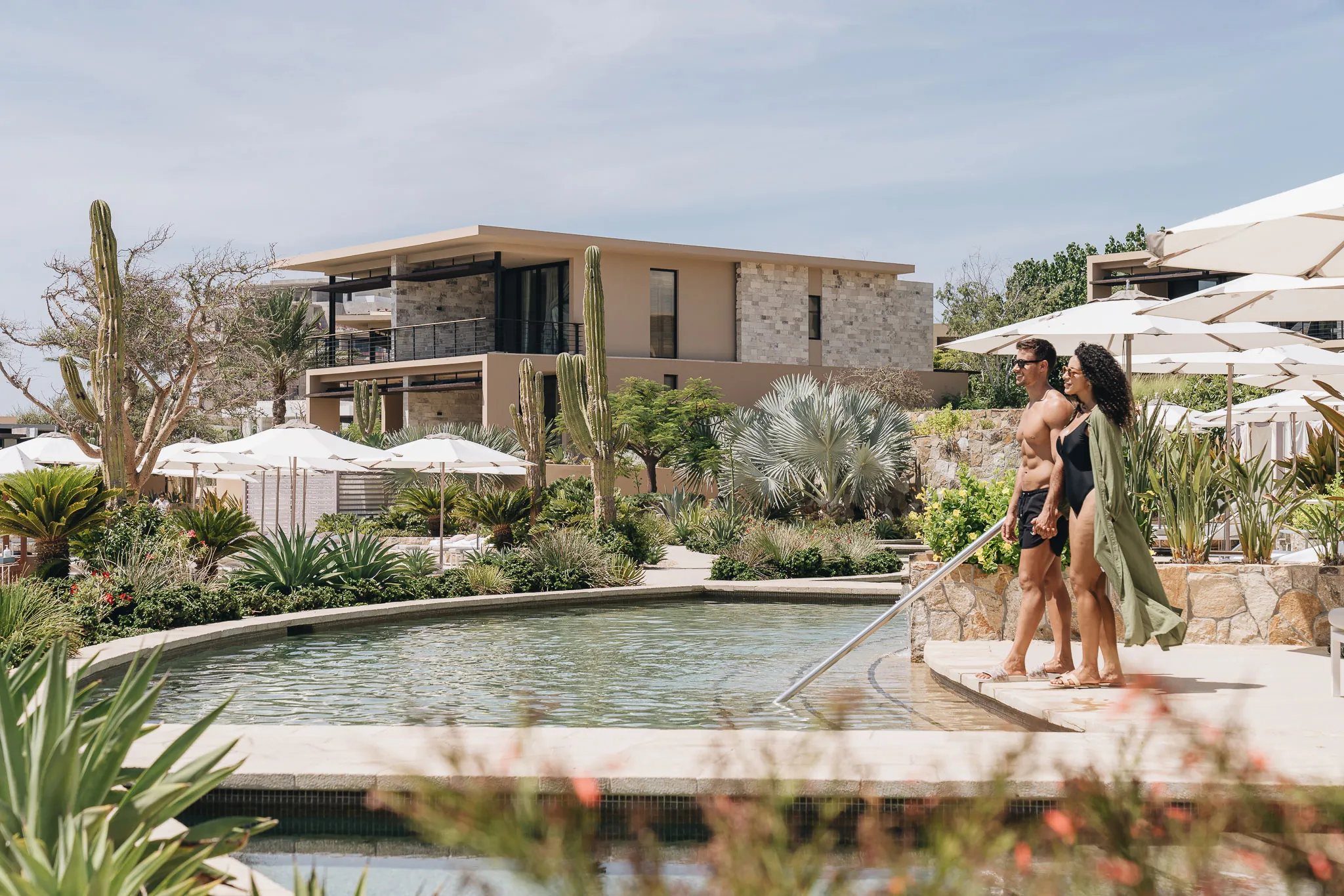 A couple walking by the pool at Montage Los Cabos