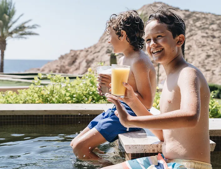 Two children drinking smoothies in the pool at Montage Los Cabos